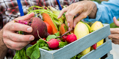 Someone picking healthy foods from a basket